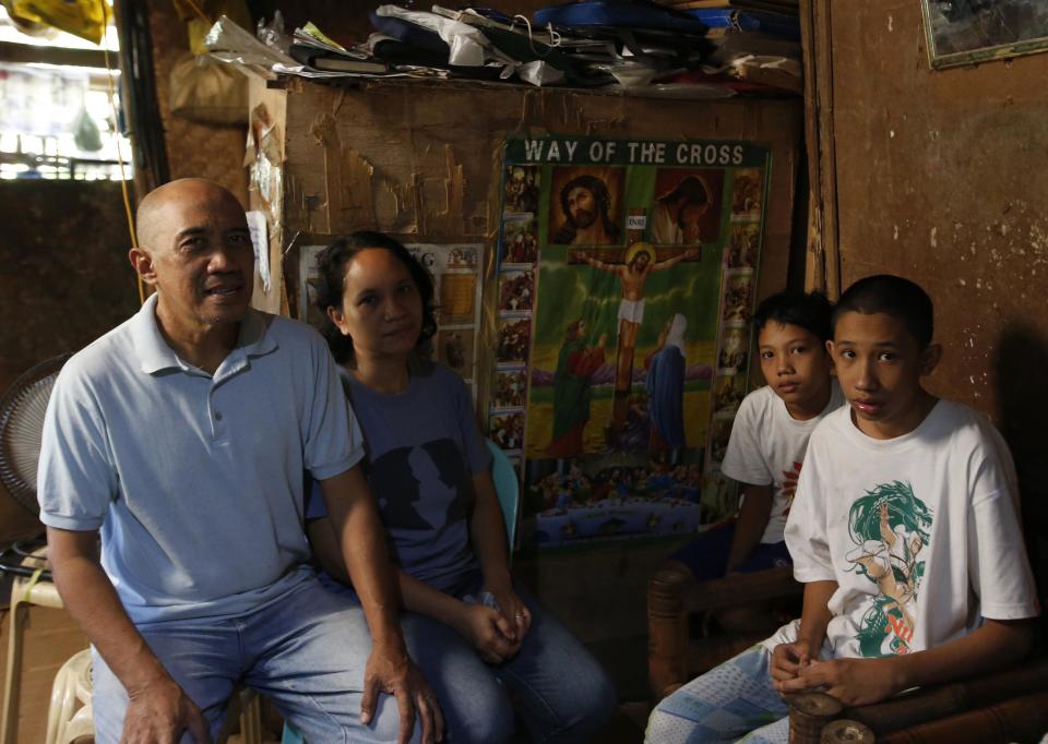 Roman Catholic priest Father Jess Siva poses with his common law wife Bemma and children at their home in Iloilo city on Panay island in central Philippines January 10, 2015. Every Sunday morning, dozens of Roman Catholics gather at a small chapel on an island in the central Philippines to listen to Father Jess Siva share his personal experiences as a priest, and as a parent. Siva, 54, has been celebrating Mass in the town of Lambunao for the past 15 years, giving communion, performing last rites for the dying, hearing confessions and officiating at marriages. But while his small flock admire him, Church leaders in the Philippines consider him persona non grata for failing to adhere to one of the most important tenets of the priesthood - abstaining from sex. Picture taken January 10, 2015. REUTERS/Erik De Castro (PHILIPPINES - Tags: RELIGION SOCIETY)