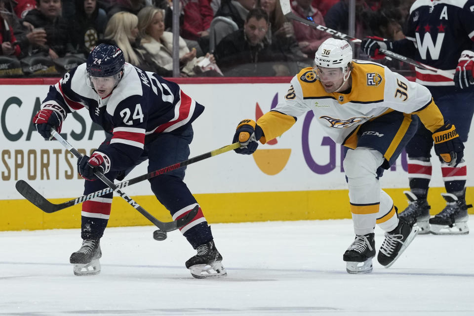 Washington Capitals center Connor McMichael (24) passes the puck past Nashville Predators left wing Cole Smith (36) during the first period of an NHL hockey game in Washington, Saturday, Dec. 30, 2023. (AP Photo/Susan Walsh)