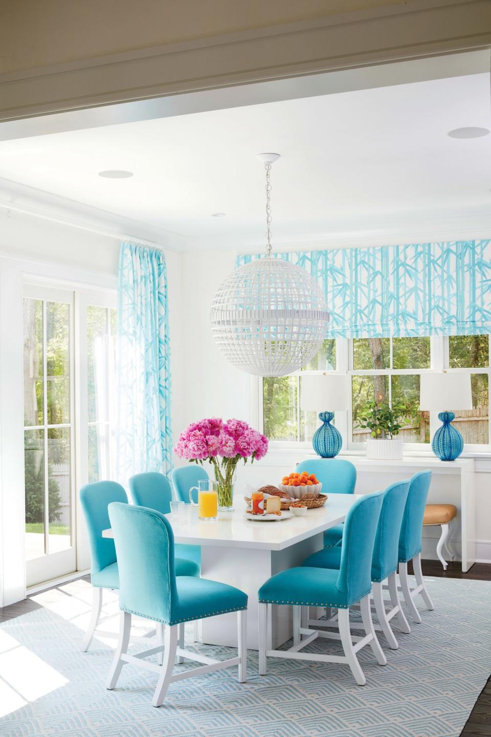 <p>Geometric elements like a striated orb chandelier and angular pedestal-base table convey a strong contemporary vibe. But paired with raffia-upholstered ottomans and curvy sea urchin table lamps, the mod elements strike a more easygoing chord.</p> <p><strong>Idea Spotlight</strong></p> <p>Frame up your views with knockout-pretty window treatments. In our Hamptons Showhouse dining room, designer Meg Braff used a turquoise-and-white bamboo pattern to draw your eye outside. Plus, the vertical nature of the pattern makes the ceilings feel higher.</p>