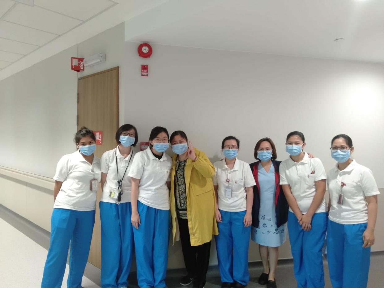 Ms Jiang (in yellow outfit) posing with doctors and nurses at the National Centre for Infectious Diseases. (PHOTO: Jiang via MOH)