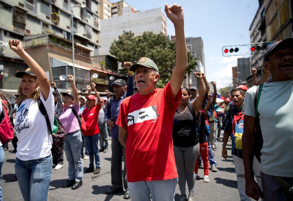 Members of the Bolivarian Militia stand in formation outside Miraflores presidential palace in Caracas, Venezuela, Tuesday, March 12, 2019. Members of the militia, which were formed the late President Hugo Chavez, met to show support for embattled President Nicolas Maduro after nearly a week of national blackouts while their country reels from economic and political calamity.