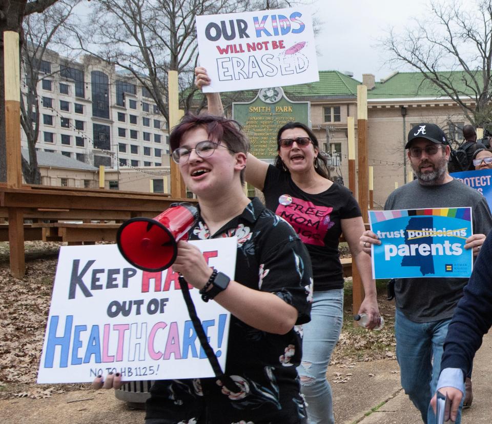 Leviathan Myers-Rowell, 16, from left, of Ocean Springs, Miss., and his parents Jodi Rowell and Thomas Rowell march from the state Capitol toward the governor's mansion following a rally at the Capitol in support of transgender youth, and in opposition to House Bill 1125 in Jackson, Miss., Wednesday, Feb. 15, 2022. HB 1125 prohibits transgender-related healthcare in Mississippi for people under the age of 18.