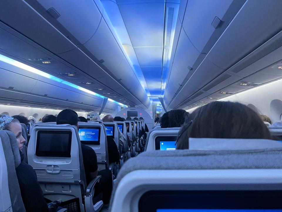 A view of the Finnair A350 cabin with blue mood lighting.