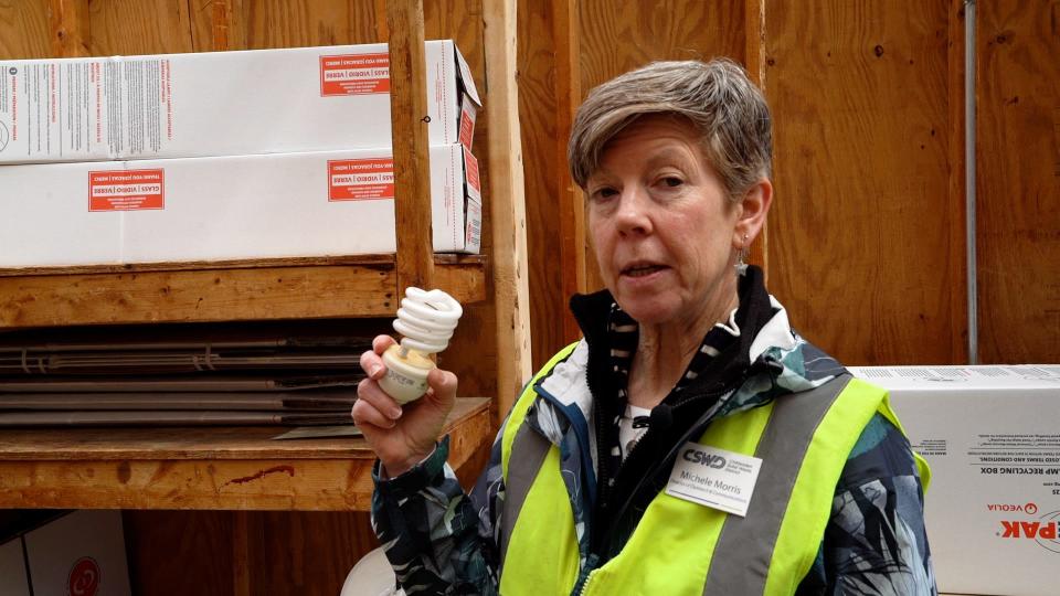Michele Morris of Chittenden Solid Waste District holds up a fluorescent lightbulb. Mercury-containing bulbs cannot go in the trash or the blue recycling bin in Vermont. They can be brought to CSWD drop-off centers.