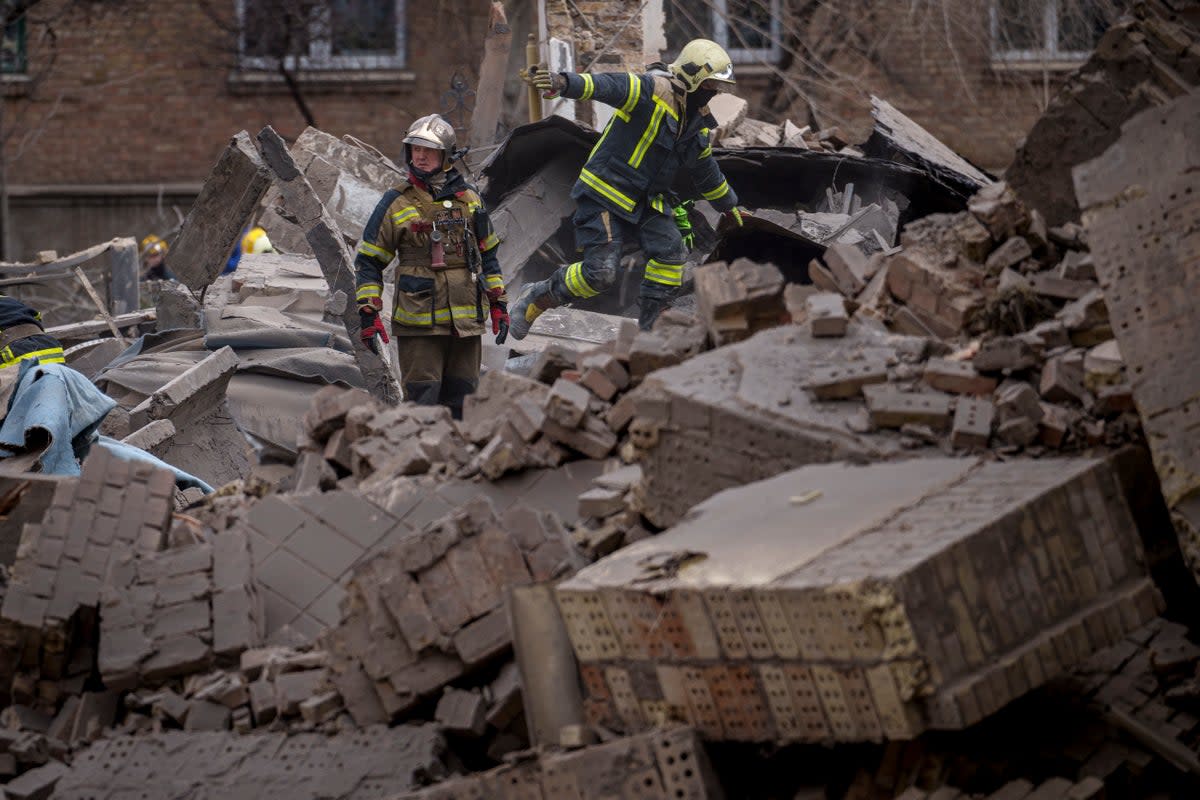 Ukrainian first responders walk in the rubble of a building in the Pecherskyi district, after a Russian air attack in Kyiv, Ukraine (AP)