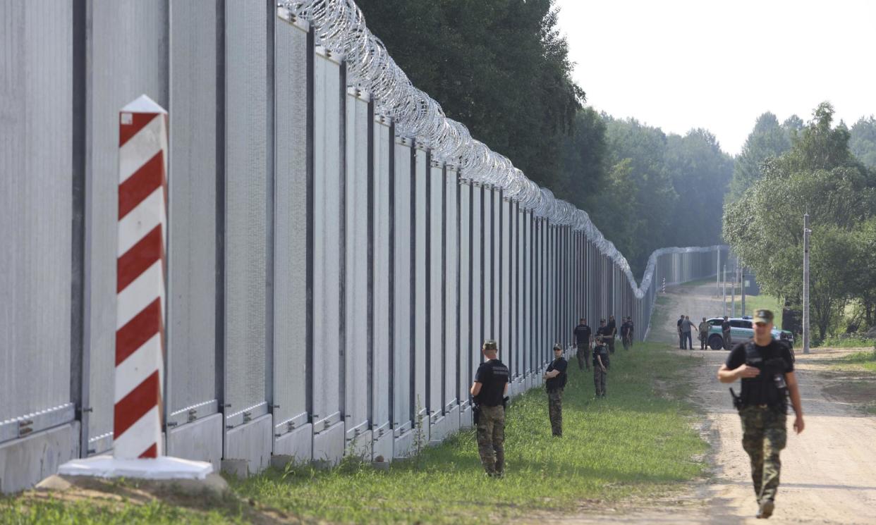 <span>Polish border guards patrol near a newly built wall on the frontier with Belarus near Kuznice in June 2022.</span><span>Photograph: Michał Dyjuk/AP</span>