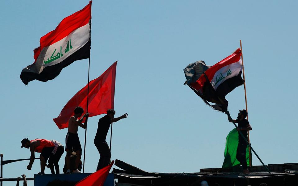 Anti-government protesters sit-in on barriers set up by security forces in Iraq - AP