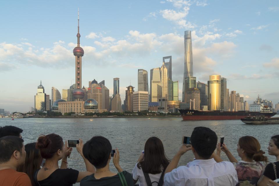 Tourists visiting the promenade on the Shanghai Bund take pictures of the Lujiazui Financial District skyline in Pudong, Shanghai, China, on Sept. 26 2016.