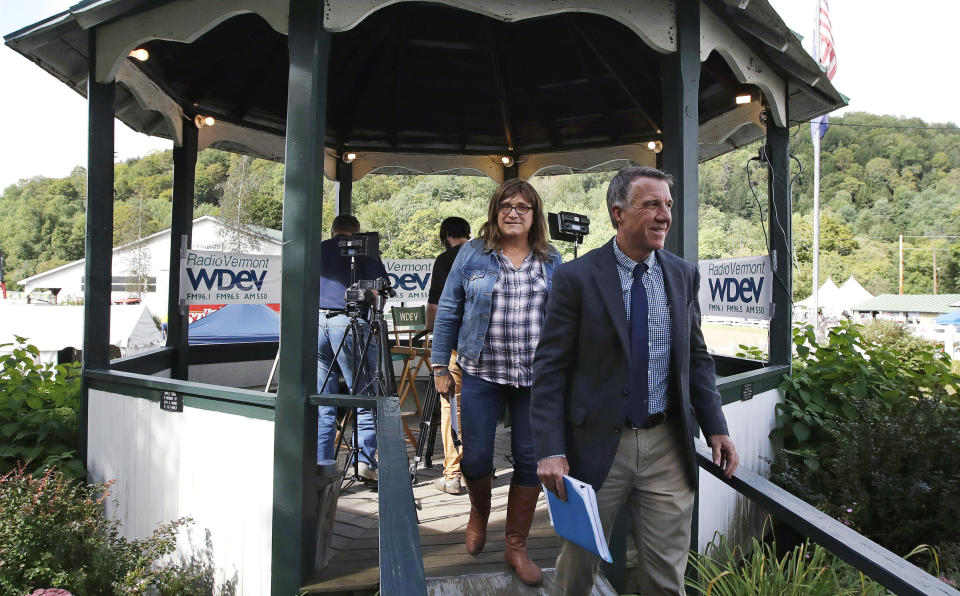 FILE - In this Friday, Sept. 14, 2018 file photo, Vermont Republican incumbent Gov. Phil Scott, right, and Democratic challenger Christine Hallquist, center, walk from a gazebo after a debate at the Tunbridge World's Fair in Tunbridge, Vt. Hallquist, former CEO of an electric company, is trying to make history as the first transgender governor. (AP Photo/Charles Krupa)