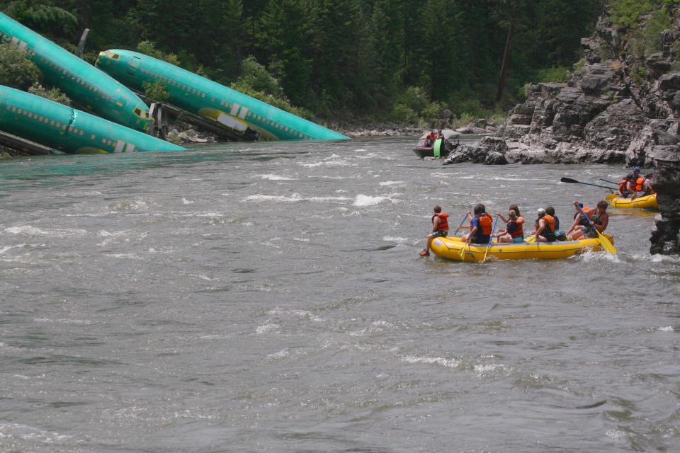 Three Boeing 737 fuselages lie on an embankment on the Clark Fork River after a BNSF Railway Co train derailed near Rivulet