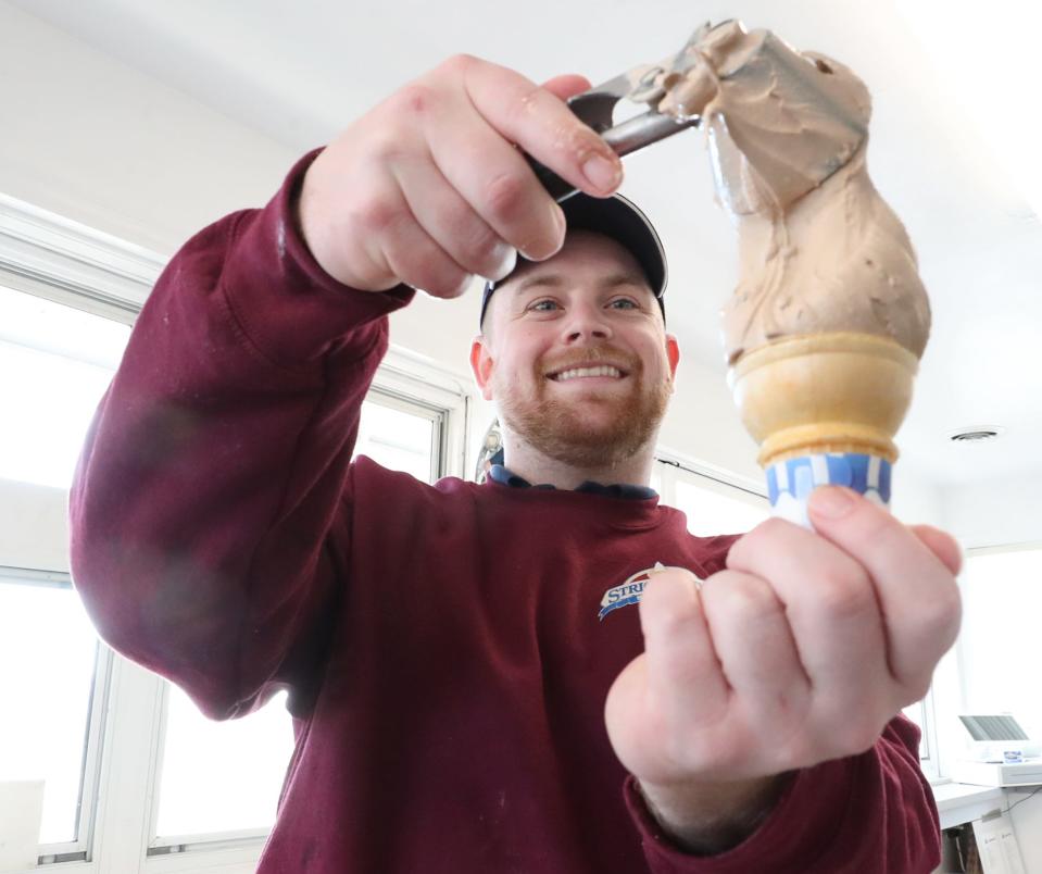 Jacob Margroff, general manager at Stricklands Frozen Custard, makes a cone of Milky Way, one of Stricklands' special offerings available on eclipse day. The Milky Way flavor is a chocolate, vanilla and caramel base custard with pieces of Milky Way candy bars mixed in.