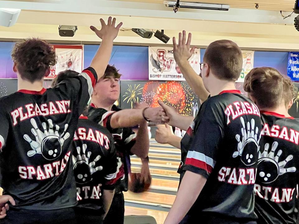 Pleasant's Dawson Hall gets high fives from teammates and coaches during last week's Division II boys bowling district tournament at HP Lanes in Columbus. Hall and his squad will return to HP Lanes on Friday for the state tournament.