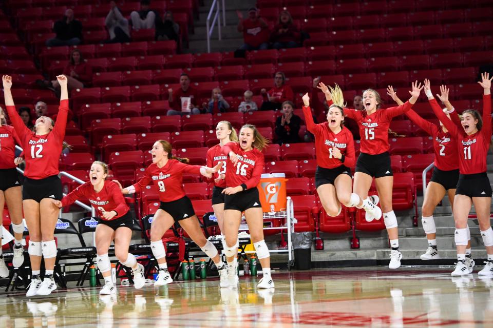 The South Dakota Volleyball team cheers from the sidelines in the second set of the Summit League Tournament championship match as they win the set 30-28 on Saturday, November 27, 2021, at the Sanford Coyote Sports Center in Vermillion.