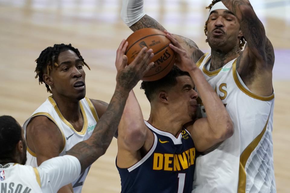 Denver Nuggets forward Michael Porter Jr. (1) is blocked from reaching the basket by Dallas Mavericks' James Johnson, left, Wes Iwundu, center rear, and Willie Cauley-Stein, right, in the second half of an NBA basketball game in Dallas, Monday, Jan. 25, 2021. (AP Photo/Tony Gutierrez)