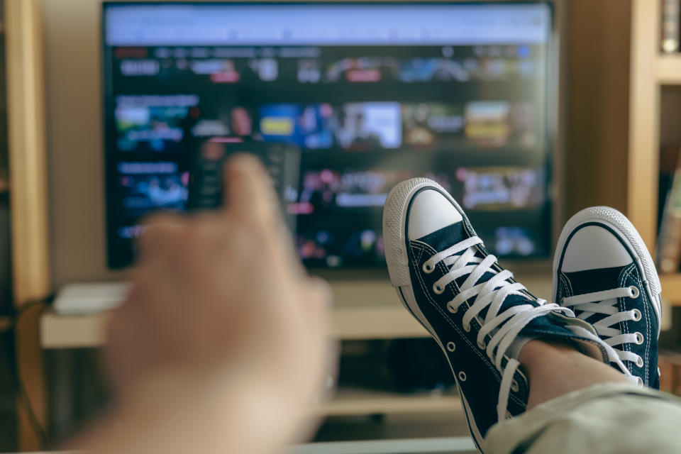 person holding a remote watching TV