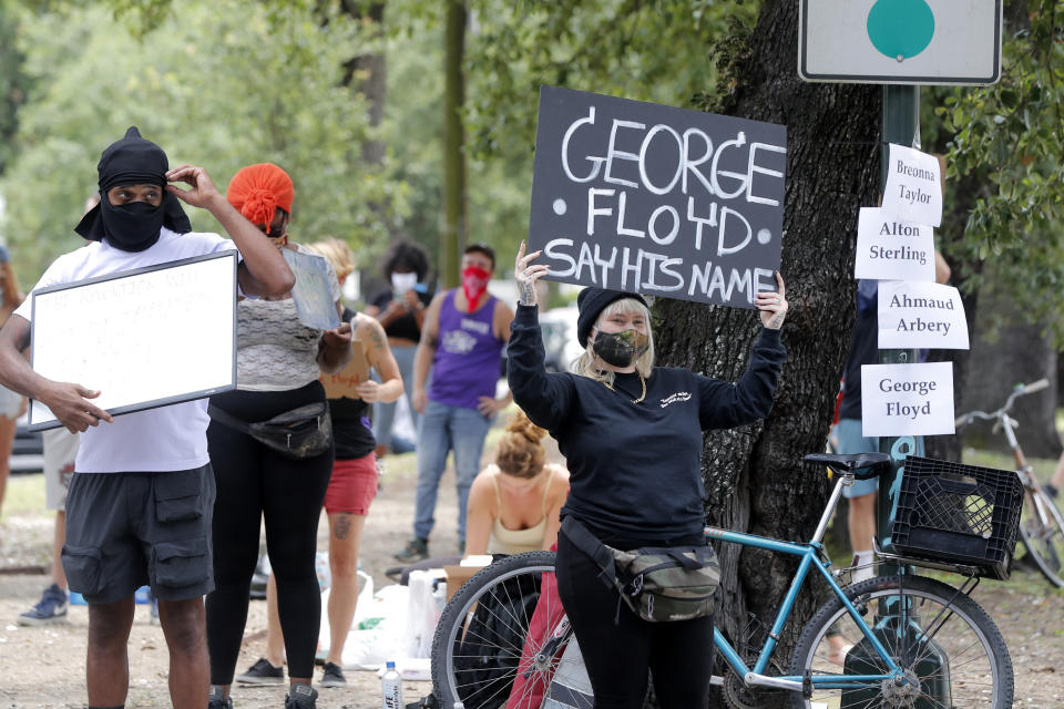 People protest the death of George Floyd, a handcuffed black man who died in the custody of the police in Minneapolis, rally on a street corner in New Orleans, Friday, May 29, 2020. (AP Photo/Gerald Herbert)