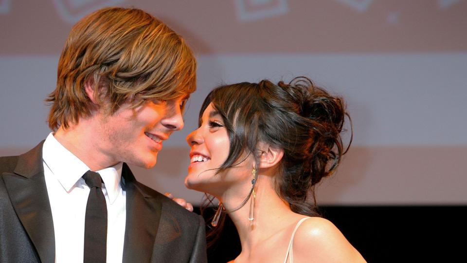 Zac Efron and Vanessa Hudgens smiling at one another