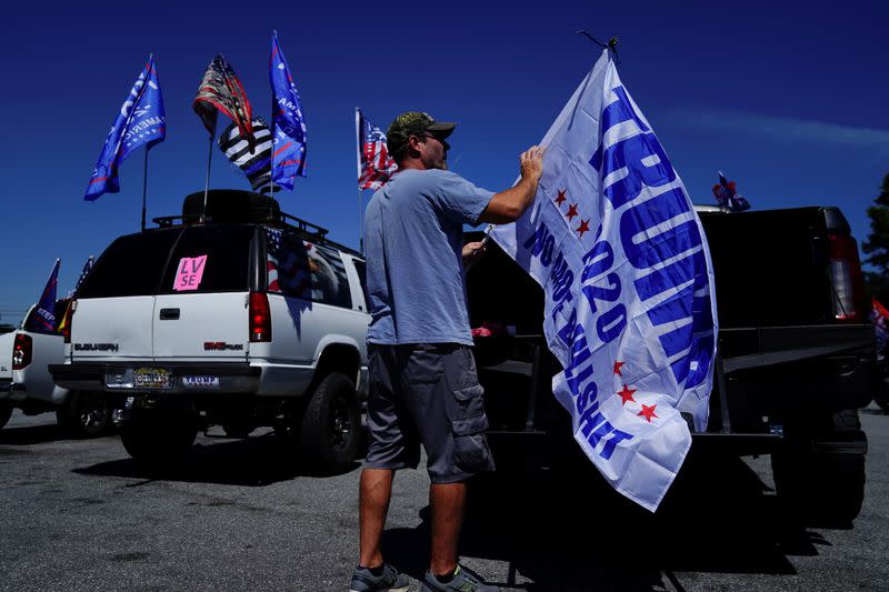 FILE PHOTO: Man attaches a pro-Trump flag to a truck after participating in a caravan convoy in Adairsville