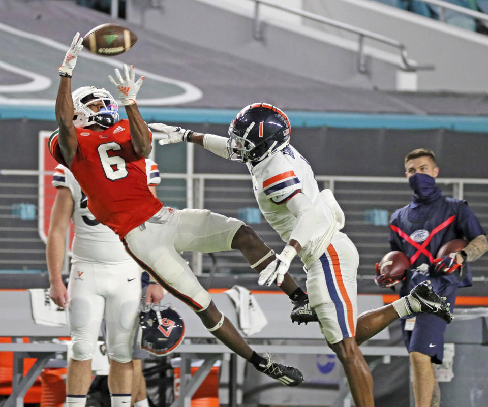 Miami wide receiver Mark Pope (6) catches a first-half pass as Virginia's Nick Grant (1) defends during an NCAA college football game in Miami Gardens, Fla., Saturday, Oct. 24, 2020. (Al Diaz/Miami Herald via AP)