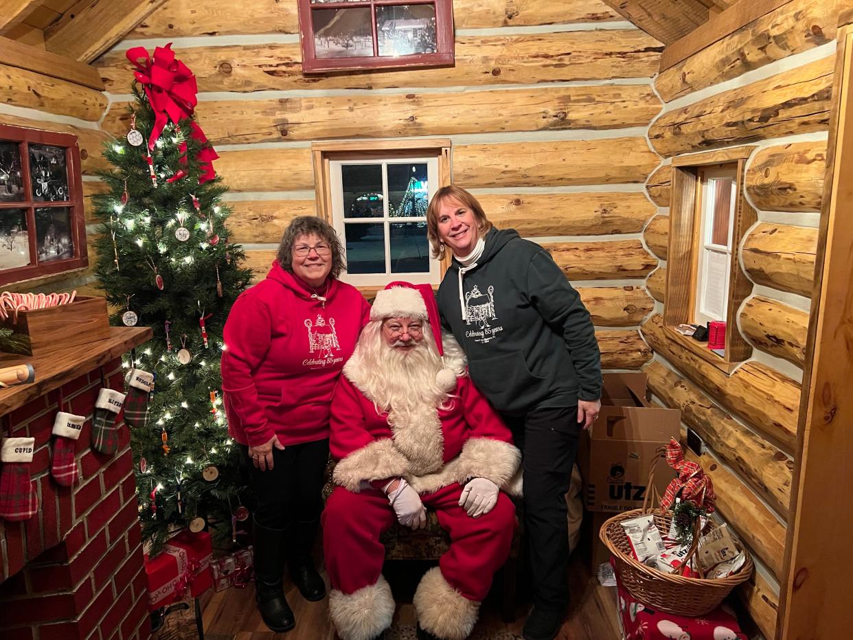 Andrea (Niehoff) Goodson (right) and Mindy Crawford smile for a photo with Santa inside his cabin during the final night of the season, December 23, 2022.
