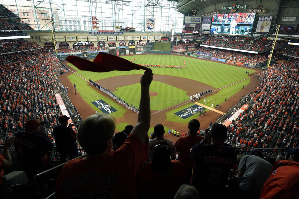 FILE - Fan cheer as the Houston Astros and the Seattle Mariners line up for the national anthem before Game 1 of an American League Division Series baseball game in Houston, Tuesday, Oct. 11, 2022. The city of Miami will host the World Baseball Classic championship game again in March 2026, concluding a tournament that also will be played in Houston, Tokyo and San Juan, Puerto Rico. (AP Photo/Eric Gay, File)