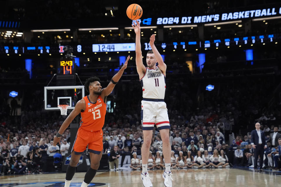 UConn forward Alex Karaban (11) takes a shot over Illinois forward Quincy Guerrier (13) during the first half of the Elite 8 college basketball game in the men's NCAA Tournament, Saturday, March 30, 2024, in Boston. (AP Photo/Steven Senne)