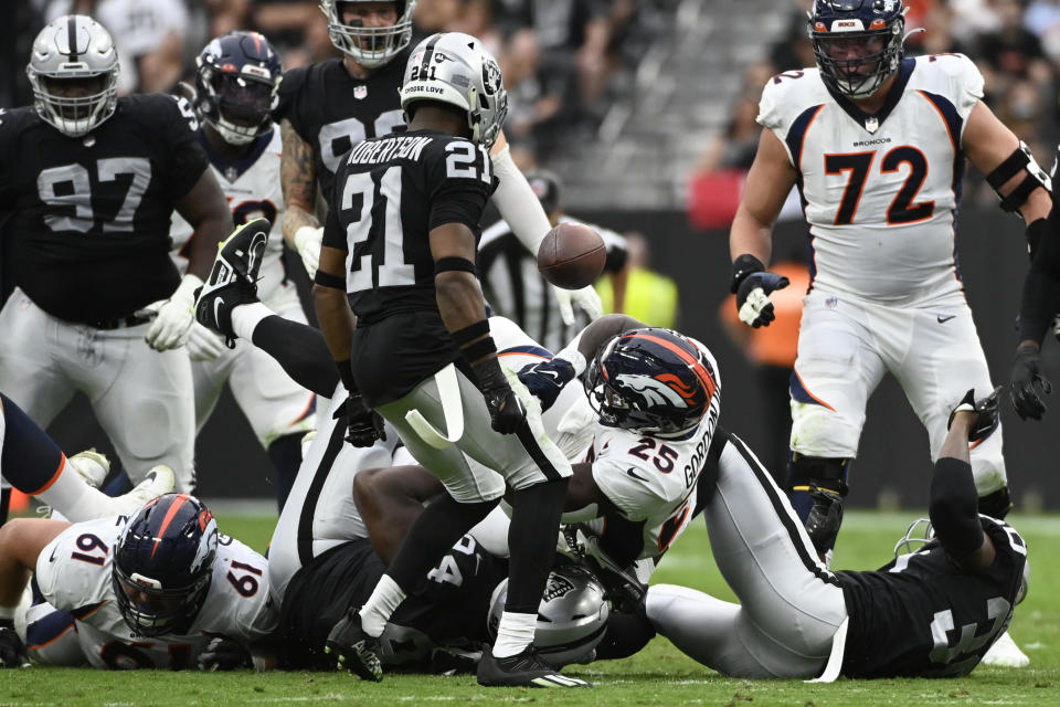Denver Broncos running back Melvin Gordon III (25) fumbles the football as Las Vegas Raiders cornerback Amik Robertson (21) recovers during the first half of an NFL football game, Sunday, Oct. 2, 2022, in Las Vegas. Robertson run the fumble back for a touchdown. (AP Photo/David Becker)