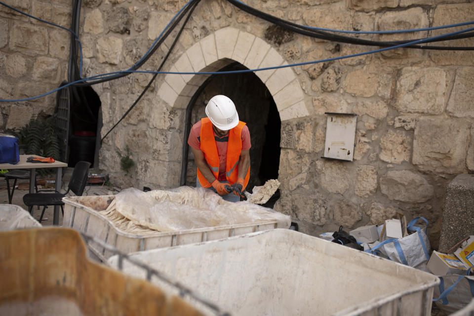 A worker prepares material to restore stone work inside the Tower of David Museum in the Old City of Jerusalem, Wednesday, Oct. 28, 2020. Jerusalem's ancient citadel is devoid of tourists due to the pandemic and undergoing a massive restoration and conservation project. (AP Photo/Maya Alleruzzo)