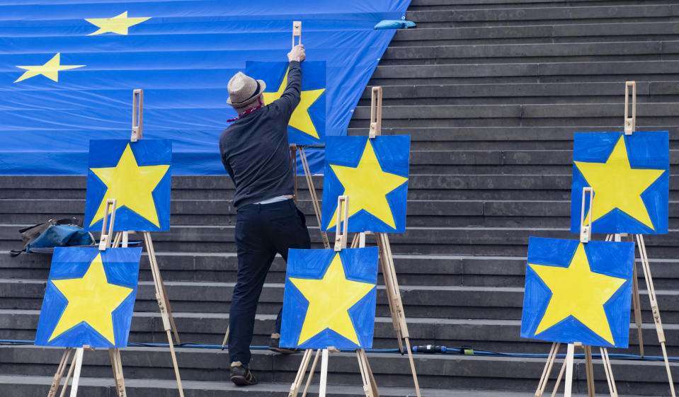 A man installs paintings of Europe Stars on stairs, during a demonstration of the 'Pulse of Europe' movement, in central Berlin, Sunday, May 27, 2019. The 2019 elections to the European Parliament will take place between May 23 and May 26. In Germany, the European election take place on Sunday, May 26, 2019. (Paul Zinken/dpa via AP)