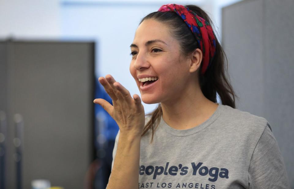 Leah Gallegos, a co-founder of People's Yoga removes her mask to teach a breathing exercise