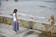 U.S first lady Melania Trump, left, and French first lady Brigitte Macron visit at the Cote des Basques beach during the G7 summit, in Biarritz, southwestern France, Monday Aug. 26 2019. (Julien de Rosa/Pool via AP)