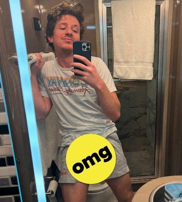 Charlie taking a selfie while wearing shorts and a T-shirt with an "omg" sticker covering his crotch area