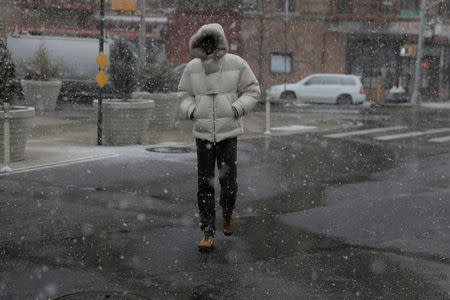 A pedestrian walks through a late season snow storm in New York, U.S., March 21, 2018. REUTERS/Lucas Jackson