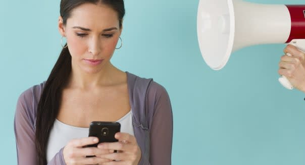 Studio shot of woman texting and ignoring voice from bullhorn