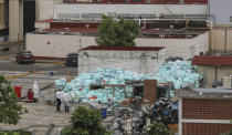 Medical workers using protective equipment dispose of trash bags containing hazardous biological waste into a large pile outside the Hospital del Instituto Mexicano del Seguro Social, which treats patients with COVID-19 in Veracruz, Mexico, Wednesday, Aug. 12, 2020. Improper disposal of medical waste has become an increasing problem in Mexico amid the pandemic. (AP Photo/Felix Marquez)