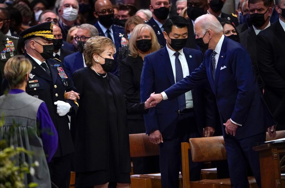 President Joe Biden reaches out to Elizabeth Dole as she arrives for the funeral service of her husband, former Sen. Bob Dole at the Washington National Cathedral in Washington D.C. on Dec. 10, 2021.