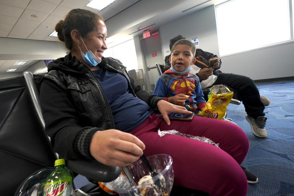 Celestina Ramirez, left, a migrant from Honduras, talks with her son Yancarlos Amaya, 5, before boarding a plane at Valley International Airport, Wednesday, March 24, 2021, in Harlingen, Texas. The mother and son, who are headed to Baltimore to reunite with Ramirez's brother, were allowed to stay in the U.S. after turning themselves in to U.S. Customs and Border Protection upon crossing the border. (AP Photo/Julio Cortez)