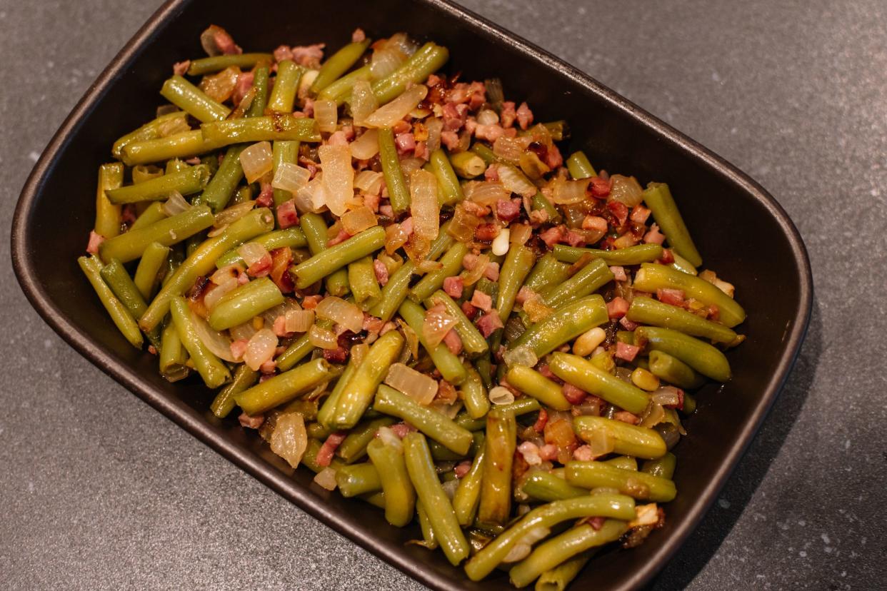 Green beans with ham. Plate of green beans cooked with serrano ham on a pyrex