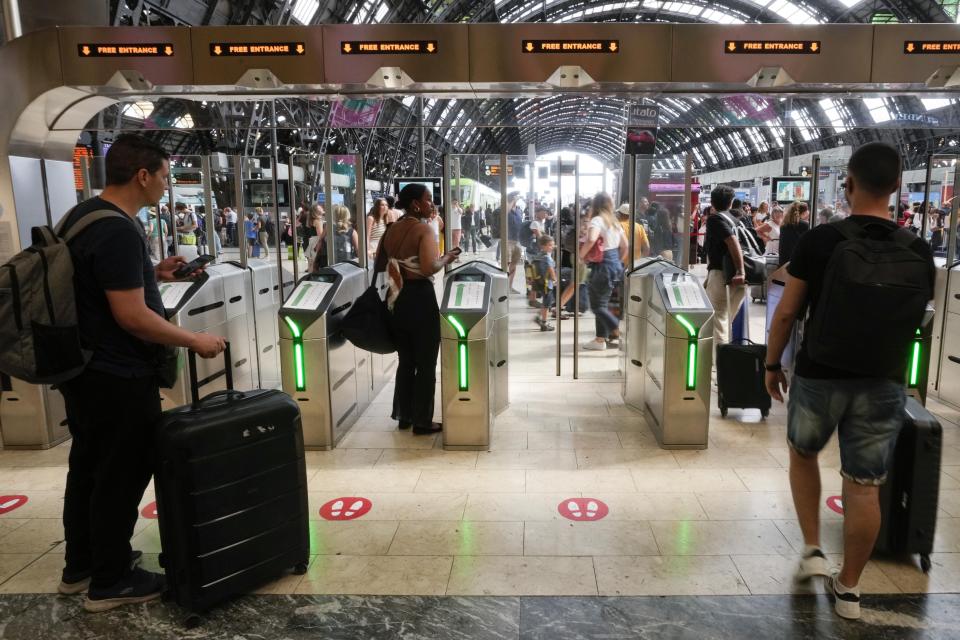 Passengers enter a gate of the Milan central station during a national train strike, Thursday, July 13, 2023. Trenitalia and Italo train workers are on strike to demand better working conditions and training. in Milan, Italy, Thursday, July 13, 2023. (AP Photo/Luca Bruno)