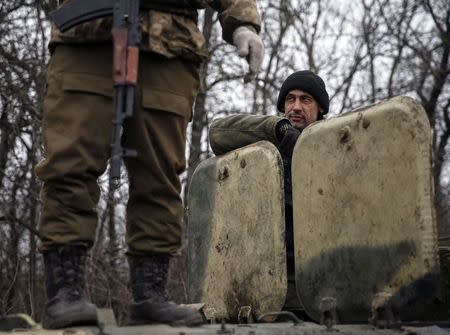 Members of the Ukrainian armed forces stand at an armoured personnel carrier as they pull back from Debaltseve region, near Artemivsk February 26, 2015. REUTERS/Gleb Garanich