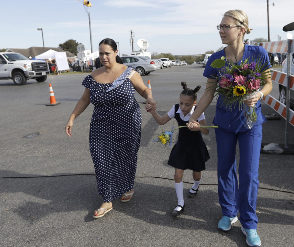 <p>Meredith Cooper, left, Holly Cooper, center, and Heather Rostrom, right, drop flowers off near the First Baptist Church of Sutherland Springs, Monday, Nov. 6, 2017, in Sutherland Springs, Texas. (Photo: Eric Gay/AP) </p>