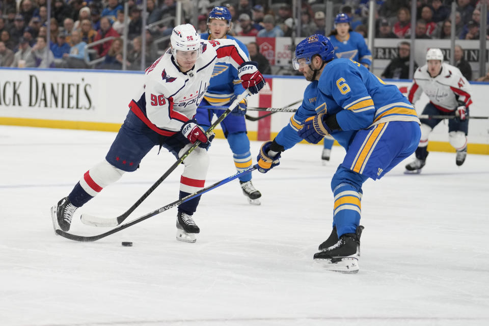 Washington Capitals' Nicolas Aube-Kubel (96) handles the puck as St. Louis Blues' Marco Scandella (6) defends during the first period of an NHL hockey game Saturday, Jan. 20, 2024, in St. Louis. (AP Photo/Jeff Roberson)