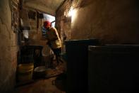 Jose Herrera carries plastic buckets with water into his house in the low-income neighbourhood of Petare amid the coronavirus disease (COVID-19) outbreak in Caracas