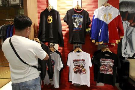 A fan looks at a jacket of boxer Manny Pacquiao of the Philippines displayed for sale inside a store in metro Manila April 24, 2015. REUTERS/Romeo Ranoco