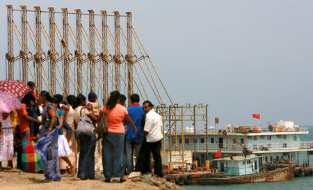 A group of Sri Lankan visitors at the new deep water shipping port watch Chinese dredging ships work in Hambantota, 240 km (150 miles) southeast of Colombo, March 24, 2010. REUTERS/Andrew Caballero-Reynolds