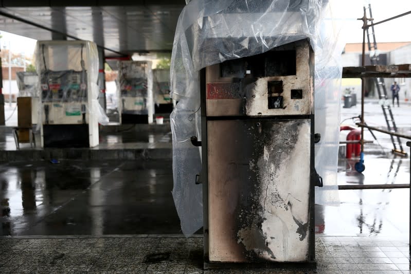 FILE PHOTO: Destroyed petrol pumps are pictured at a gas station, after protests against increased fuel prices, in Tehran