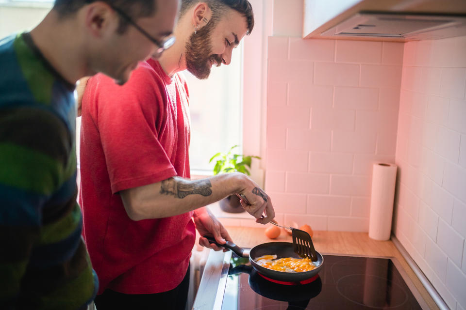 Gay couple cooking eggs in kitchen, the top thing you should know about your partner. (Getty Images)