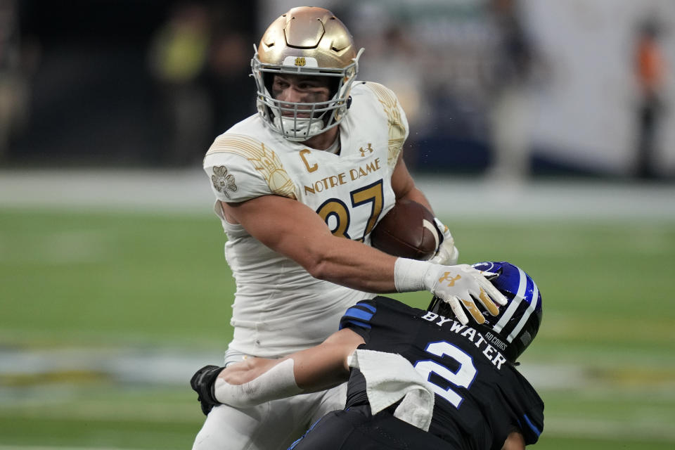 Notre Dame tight end Michael Mayer (87) makes a catch over BYU linebacker Ben Bywater (2) during the first half of an NCAA college football game Saturday, Oct. 8, 2022, in Las Vegas. (AP Photo/John Locher)