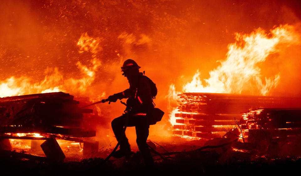 A firefighter douses flames as they push towards homes during the Creek fire in the Cascadel Woods area of unincorporated Madera County, California on 7 September 2020