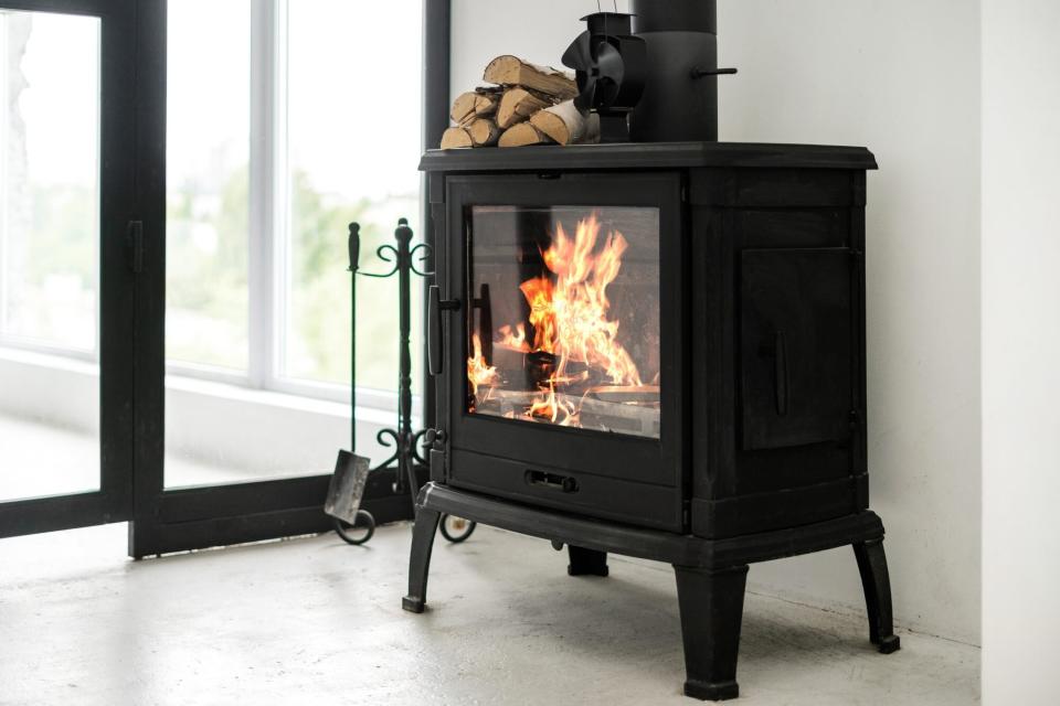 Cast iron fireplace in home burning with wood